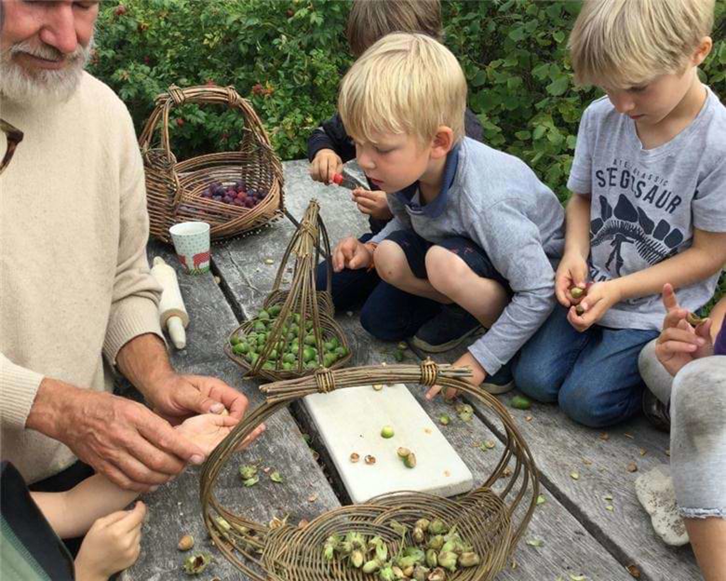 Pædagog med børn på bordet, der kigger på agern
